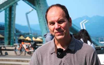 Transportation Engineer Dale Bracewell in front of the 2010 Olympic torches in downtown Vancouver's Jack Poole Plaza
